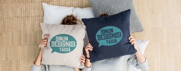 Kaksi naista peittää kasvonsa itse suunnitelluilla tyynynpäällisillä