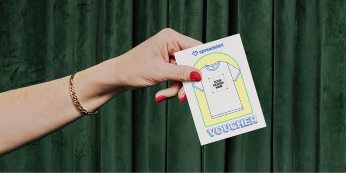 A hand with red nails holds a white card bearing the inscription 