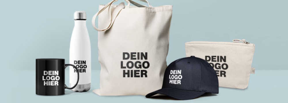 Schwarze Tasse, weiße Trinkflasche, Stoffbeutel und Täschchen in Naturweiß sowie schwarzes Cap mit Aufdruck „Dein Logo hier“