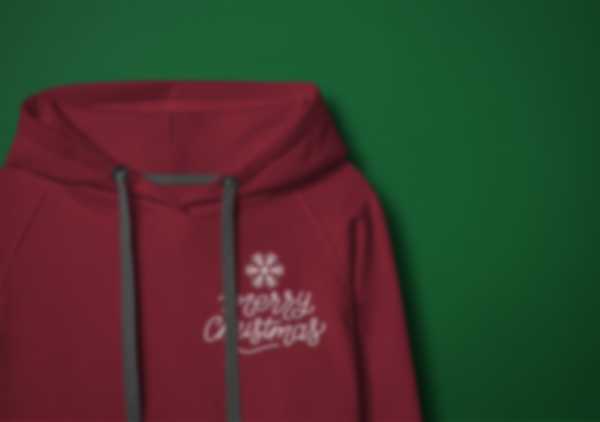 Embroidered Merry Christmas lettering on a burgundy hoodie against a green background