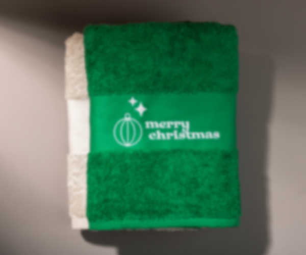 Beżowy i zielony ręcznik z haftowanym napisem Merry Christmas i świątecznymi motywami