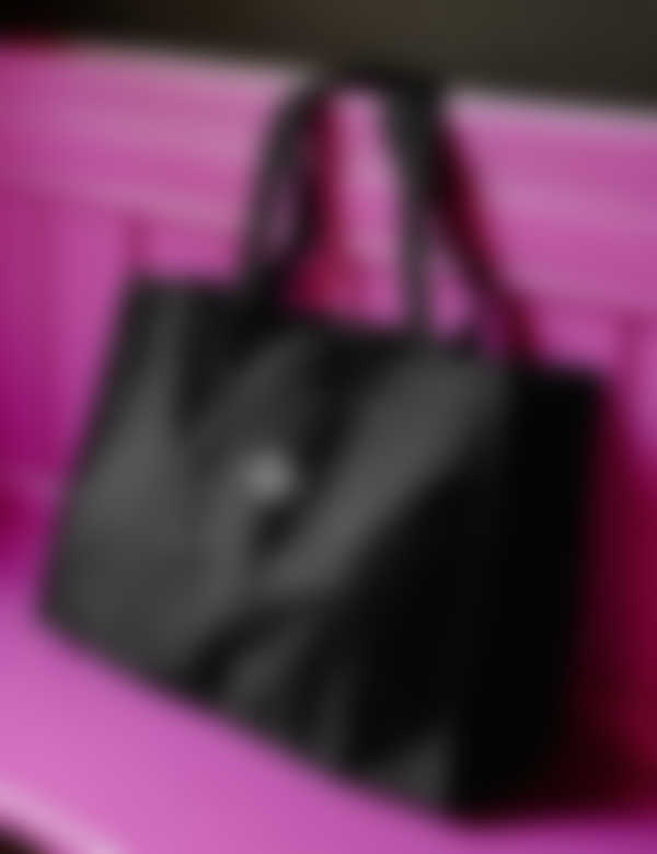 Sort shoppingtaske med personligt design på pink træbænk