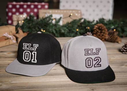 Deux casquettes Snapback personnalisées posées dans un déco de Noël