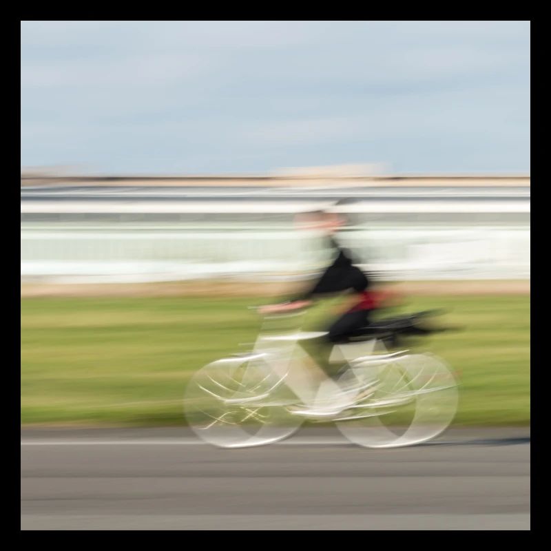 Radfahrerin in Bewegung auf einer geraden Asphaltstraße