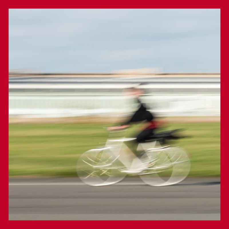 Radfahrerin in Bewegung auf einer geraden Asphaltstraße
