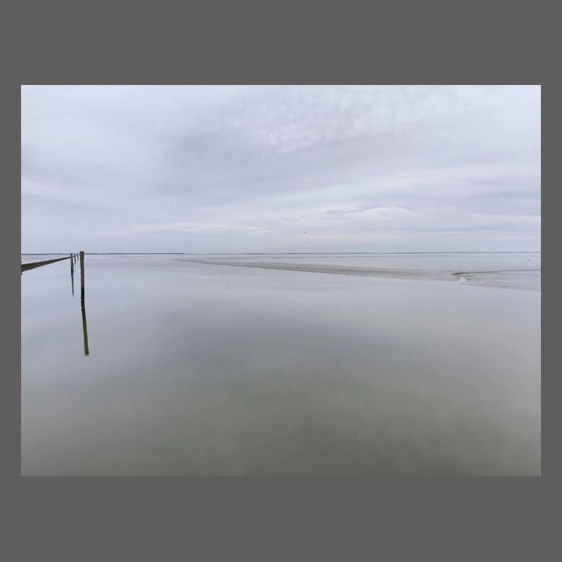 Silent seashore with sky reflection