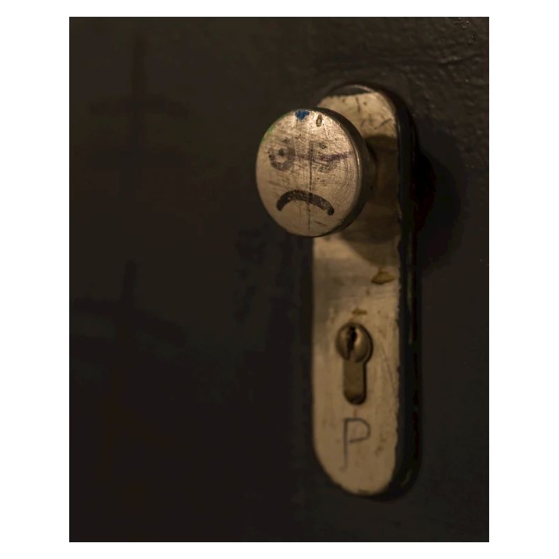 A doorknob with a bad tempered face painted on it