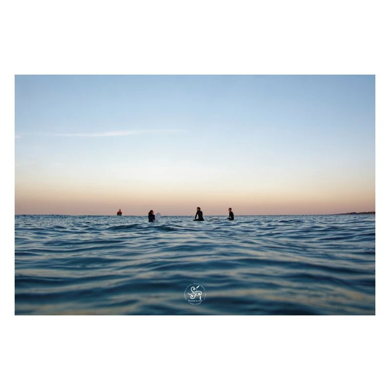 Crépuscule sur l’océan et surfeurs