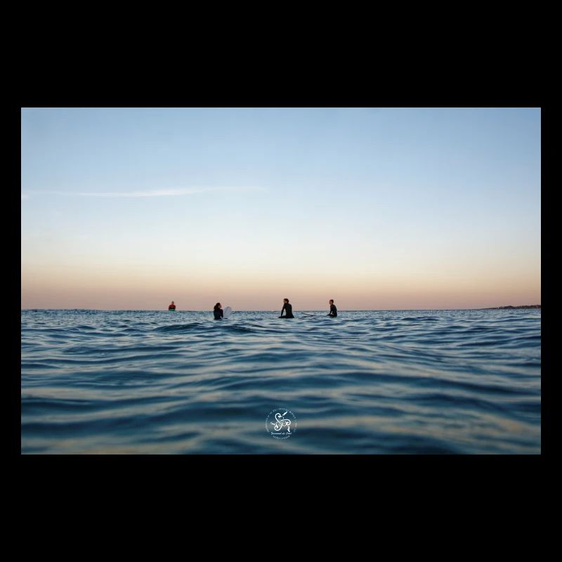 Crépuscule sur l’océan et surfeurs