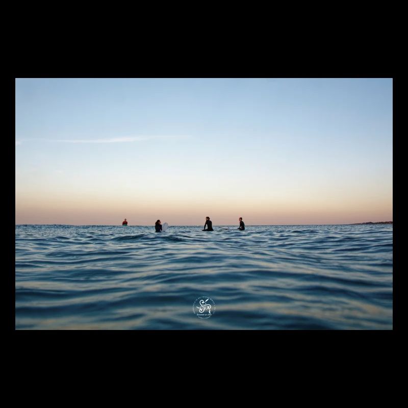 Dämmerung über dem Ozean und Surfern