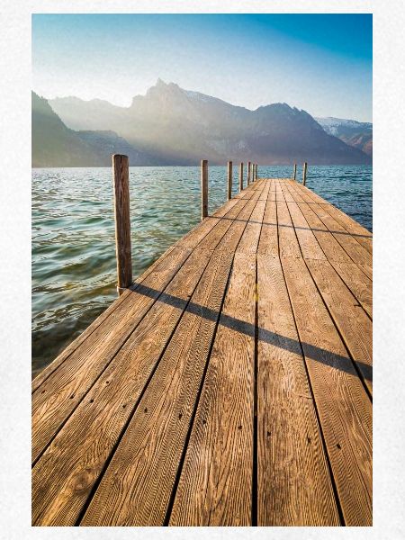 Holzsteg am Bergsee im Sonnenlicht