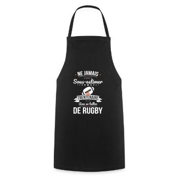 Sous-estimer un trentenaire avec ballon de rugby - Tablier de cuisine - noir - Devant - AI Model Male 185 dark (185cm)
