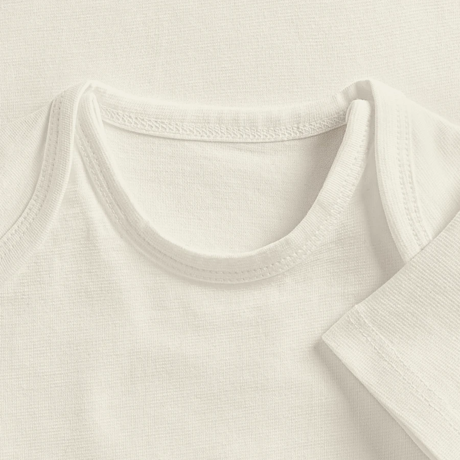 Grindelwald badge on a baby premium organic t-shirt, off white, close-up