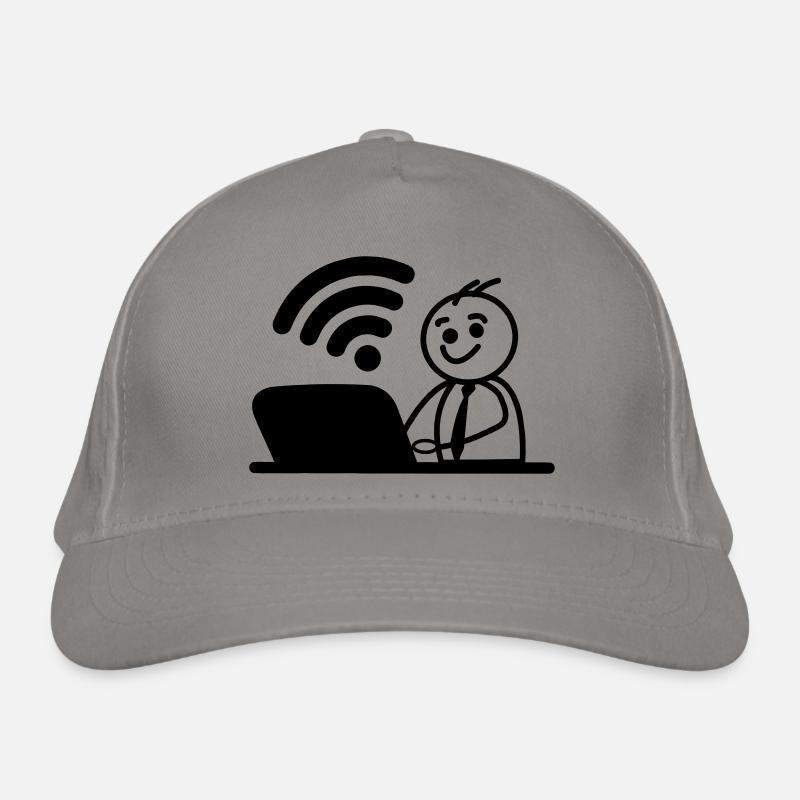 Glücklicher junger Mann auf Laptop-WLAN sendet eine Nachricht Bio-Baseballkappe