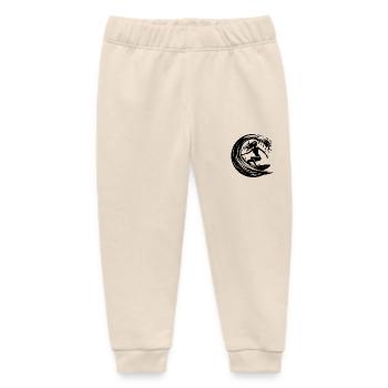 Elegante Surferin mit Surfbrett im Wellen Tunnel - Baby Organic Jogginghose Baby Tumbler von Stanley/Stella - Natur - Vorne