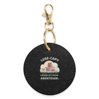 Capybara reading between stacks of books - Round Keyring - black - Front