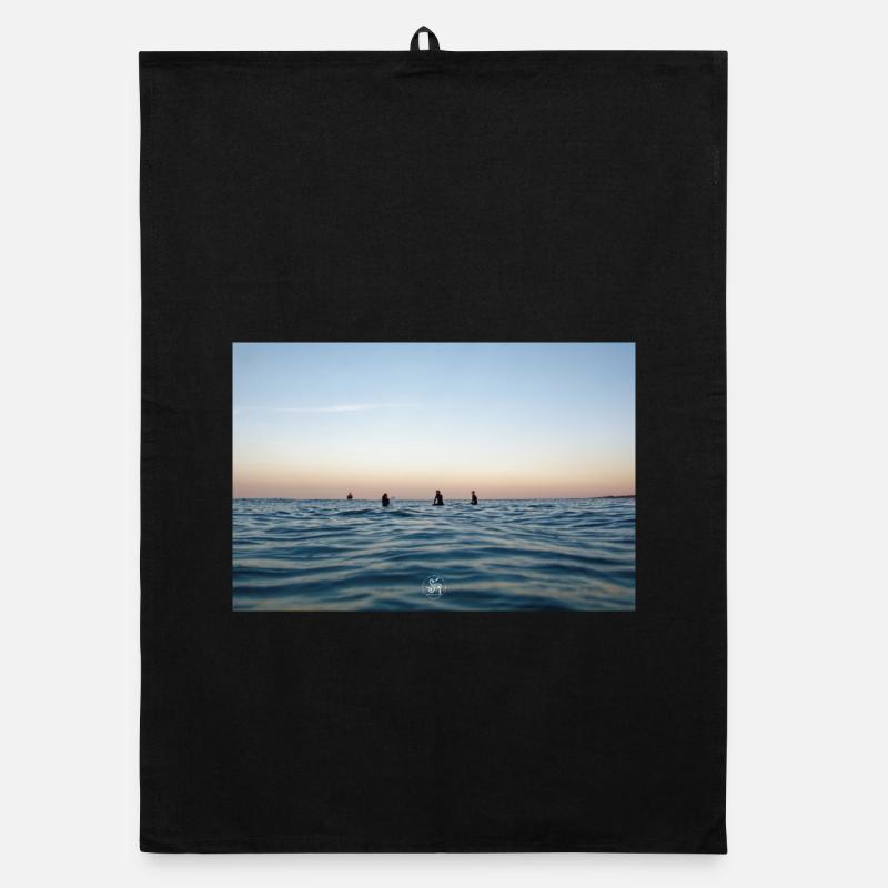 Crépuscule sur l’océan et surfeurs Torchon bio