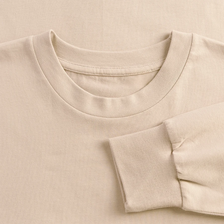 Grindelwald badge on a oversized long sleeve t-shirt, sand, close-up