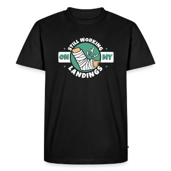 Je travaille toujours sur mes atterrissages Os du doigt cassé - T-shirt Premium bio Homme - noir - Devant - Nico (187cm)
