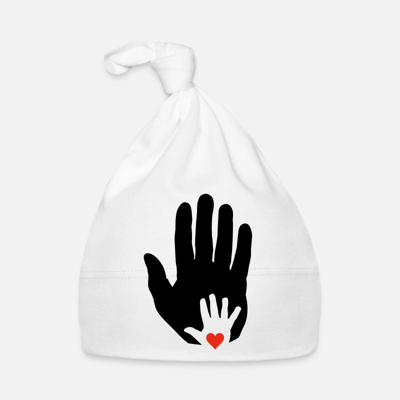 Cœur dans la main de bébé dans la main plus âgée! Bonnet bio Bébé